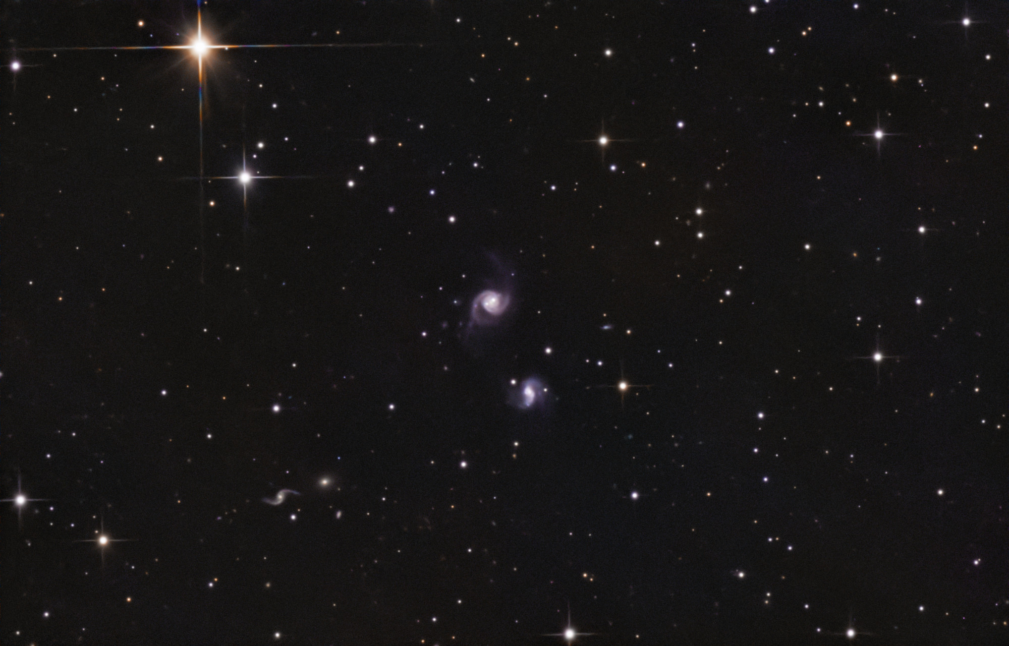 NGC5993-3_sessions Aufnahme mit der Planetenkamera ZWO ASI662MC durch den Skywatcher 130/650PDS. Eigentlich wollte ich eine Supernova in der Galaxie NGC 5993 aufnehmen, doch diese liegt genau neben dem Zentrum dieser Galaxie, ist genauso hell wie dieses und kann deshalb von meinem kleinen Teleskop nicht auseinandergehalten werden, das Auflösungsvermögen ist hier zu gering. So bleibt mir eben nur eine Aufnahme von ein paar sehr weit entfernten und selten abgebildeten Galaxien. Mittig: NGC 5993, darunter: NGC 5992. Belichtungszeit: ca. 7 h.